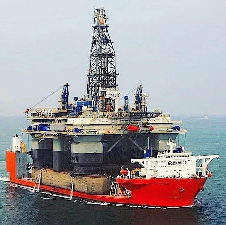 Offshore drilling rig on a red heavy-lift ship at sea