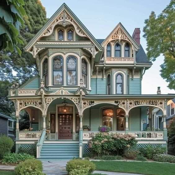 Detailed Victorian house with ornate trim, turret, and wraparound porch surrounded by greenery