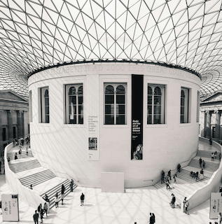 Black-and-white interior view of the British Museum courtyard beneath a geometric glass roof