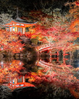 Japanese temple and red bridge amid autumn foliage reflected in a calm pond at Daigo-ji, Kyoto