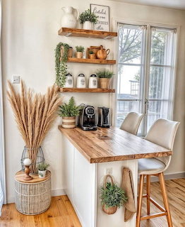 Bright kitchen corner with wood shelves, plants, coffee machine, and two bar stools by a window
