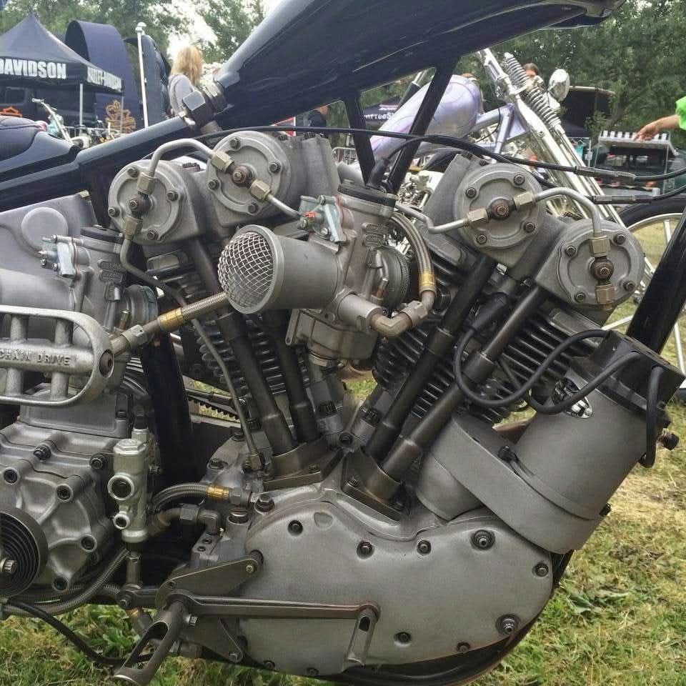 Close-up of a custom Frankenstein Harley-Davidson V-twin engine with dual carburetors and exposed mechanical parts