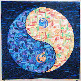 Yin yang symbol made from colorful patchwork fabric pieces on quilted dark blue background