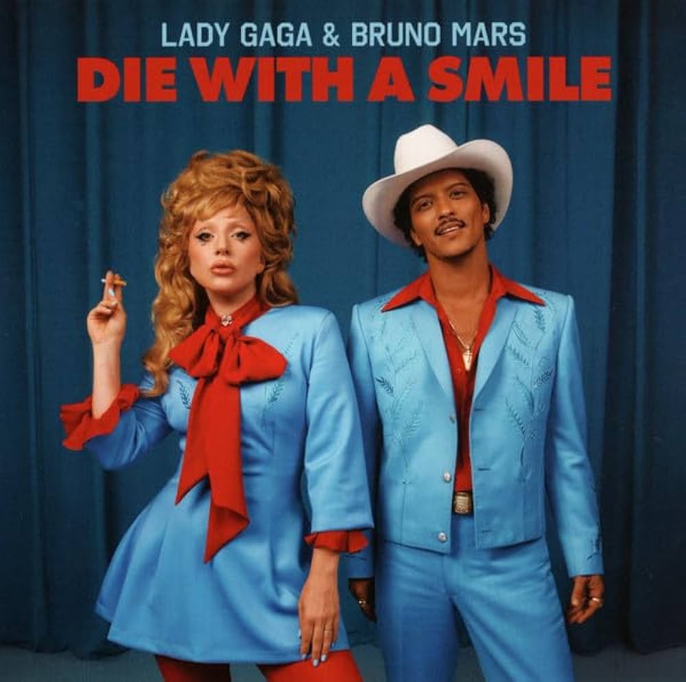 Lady Gaga and Bruno Mars in matching light blue outfits standing in front of blue curtains