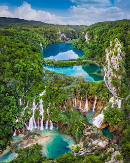 Aerial view of Plitvice Lakes with turquoise water, waterfalls, and dense green forest in Croatia