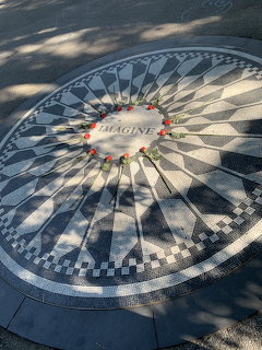 Imagine mosaic tile memorial in Central Park with roses arranged in a circle around the center