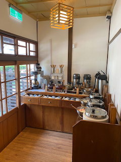 Wooden counter with coffee dispensers and cups in restaurant interior