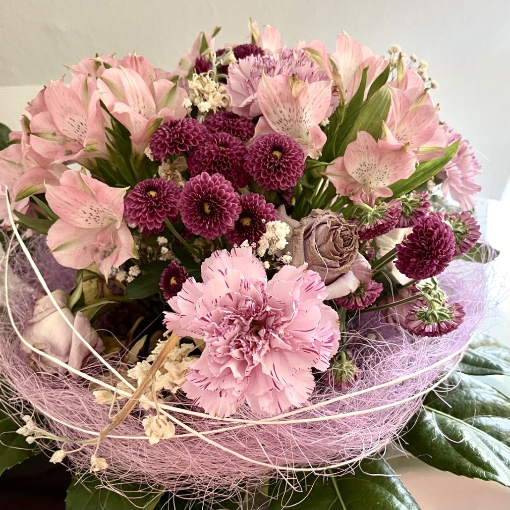 Pink and purple flower bouquet with dahlias and chrysanthemums in decorative netting