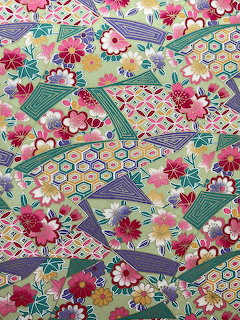 Colorful Japanese chiyogami pattern with flowers, hexagons, and geometric shapes on green background