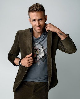 Young man in olive blazer smiling at camera in studio portrait