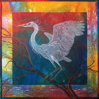 White heron art quilt with wings spread on branch, colorful patterned border