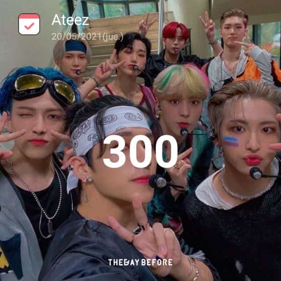 Ateez members posing for a close-up indoor group selfie with microphones and peace signs