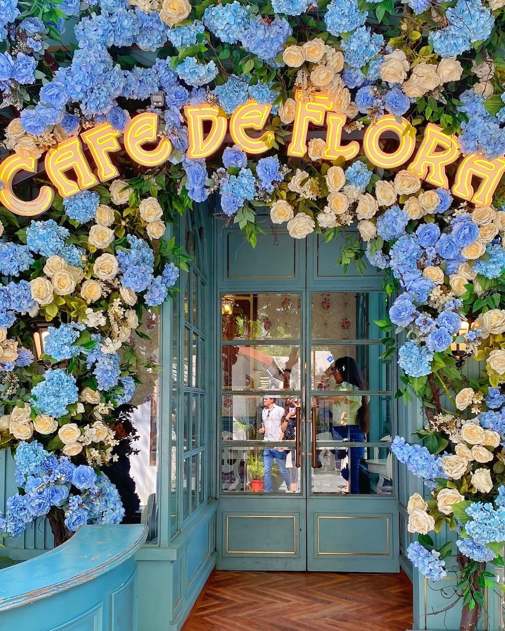 Cafe De Flora exterior in Delphi with flowers and outdoor seating