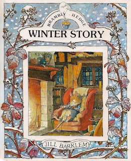 Brambly Hedge Winter Story book cover with mice characters in warm interior scene surrounded by winter botanical border