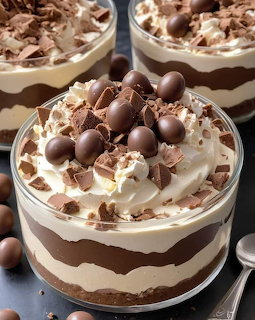 Layered chocolate mousse dessert with whipped cream and chocolate toppings in glass cups