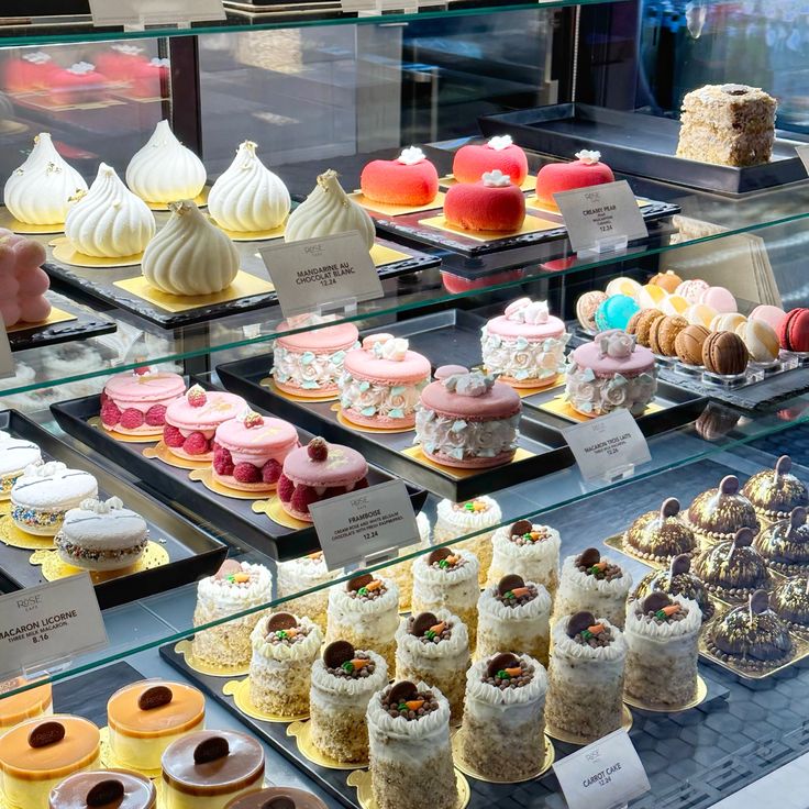 Glass pastry case with colorful macarons, cakes, and desserts in a cafe