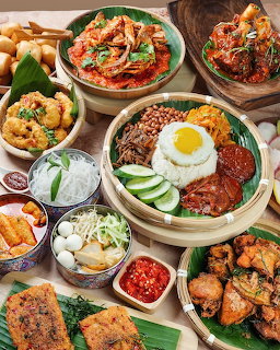 Overhead view of a Korean meal spread with rice, egg, kimchi, noodles, fried chicken, and side dishes