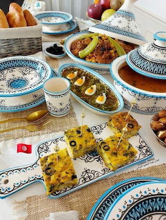 Traditional Ramadan iftar meal with dishes, dates, pastries and blue-patterned plates on decorated table