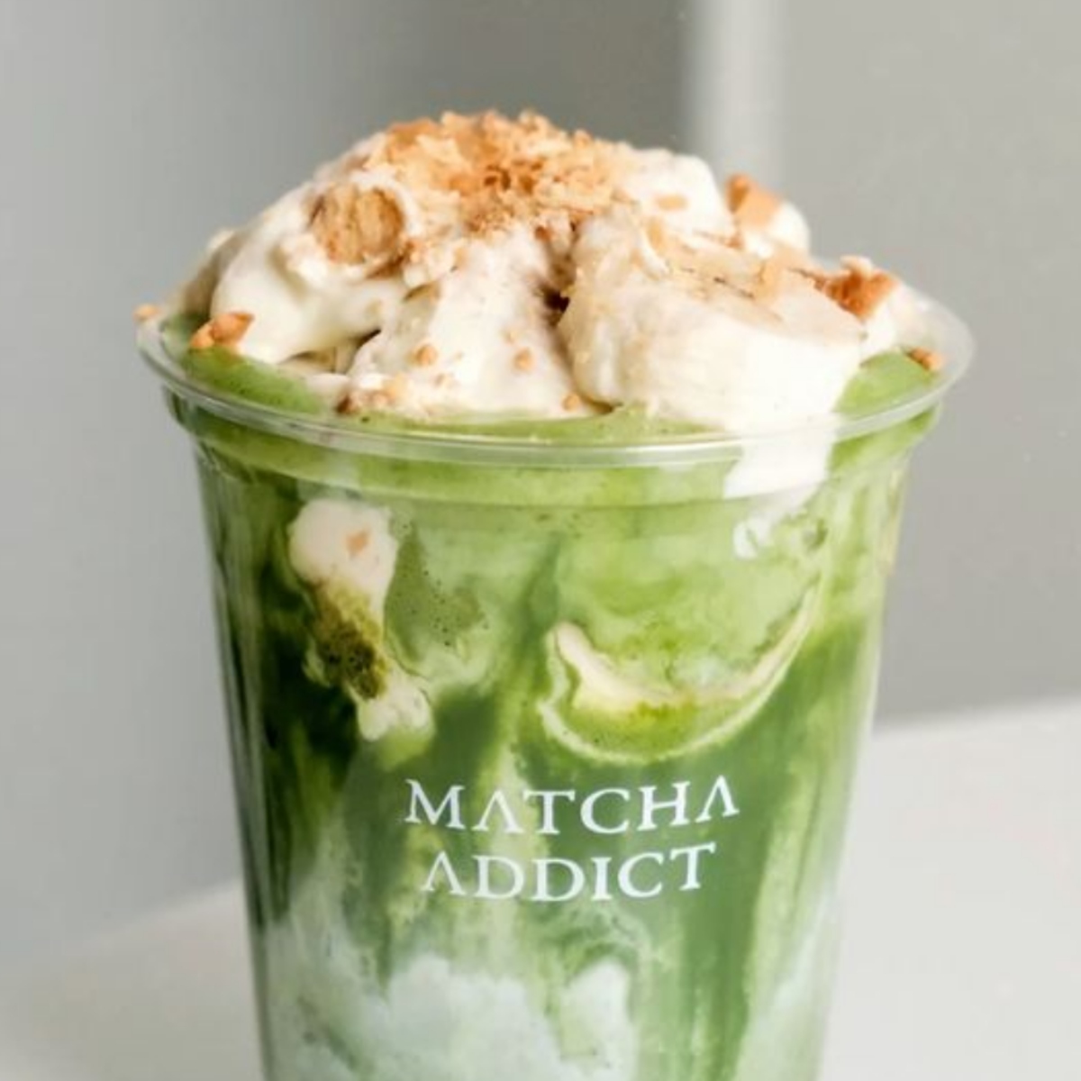 Green matcha float in a clear cup topped with vanilla ice cream