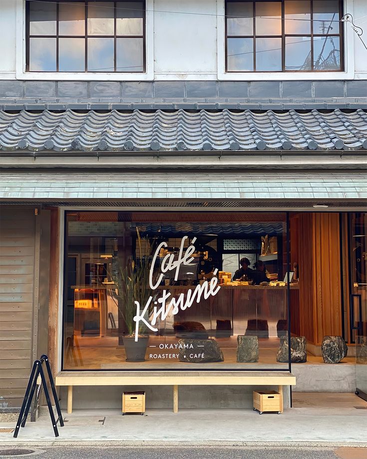 Café Kitsuné Okayama storefront with traditional Japanese tiled roof and large glass window display