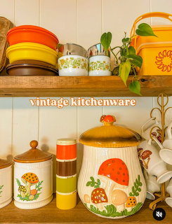 Vintage ceramic kitchen canisters, bowls, and mugs on rustic wooden shelves