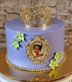 Purple princess-themed cake with gold crown and portrait medallion
