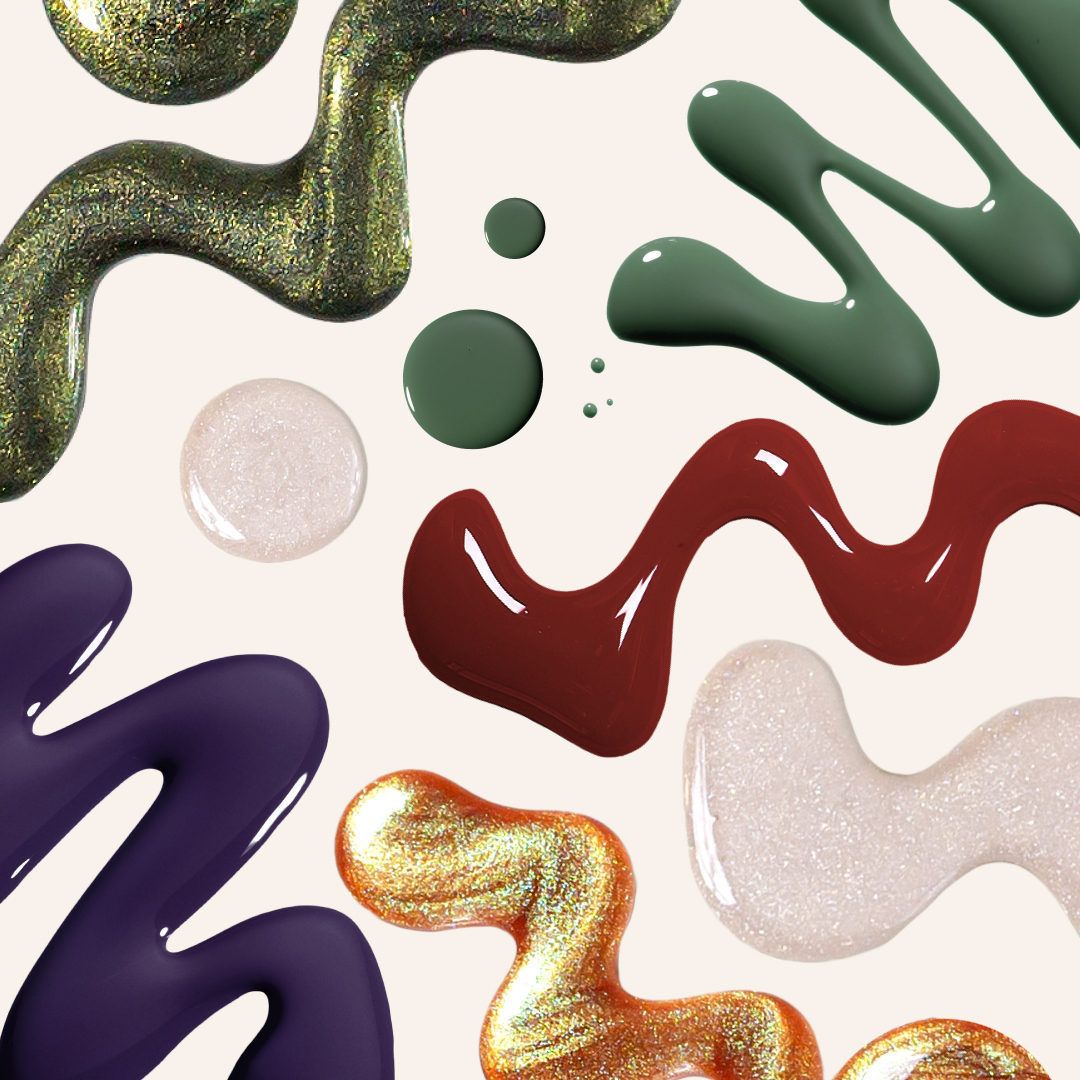 Colorful makeup smears and cosmetic swatches arranged on a light background