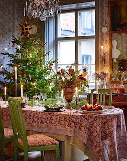 Victorian dining room with Christmas tree, ornate red tablecloth, chandelier, and holiday decorations