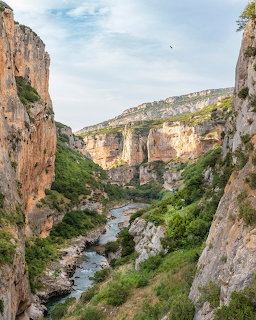 River winding through a rocky canyon with tall cliffs and green vegetation