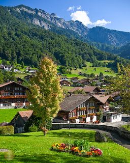 Traditional Swiss chalets and green meadows in Brienz with mountain backdrop