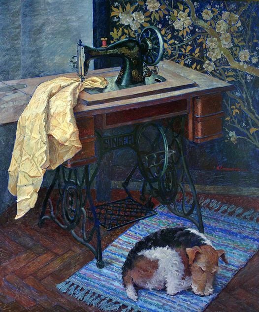 Vintage sewing machine with yellow fabric and beagle dog resting underneath on striped rug
