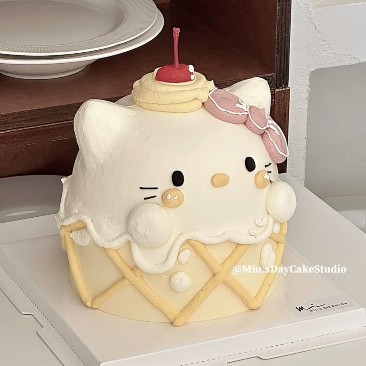 Hello Kitty cake shaped like melting ice cream on waffle cone with cherry and pink bow