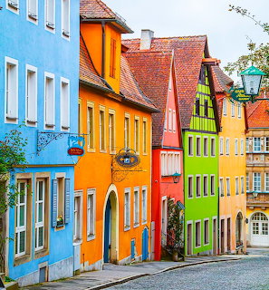 Row of colorful traditional houses with red roofs on a cobblestone street in a German village