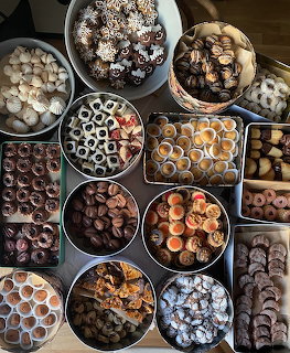 Assorted Christmas cookies in round tins and baking sheets viewed from above