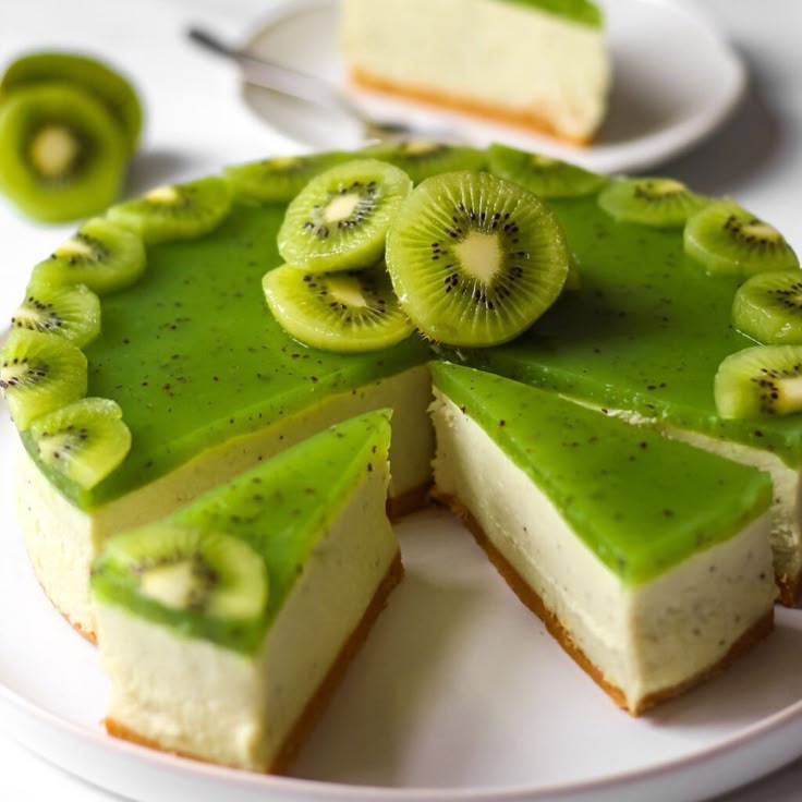 Kiwi cheesecake with green glaze and fresh kiwi slices, one slice cut out