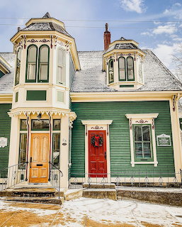Two Victorian houses with bay windows and red doors in winter, Lunenburg Nova Scotia
