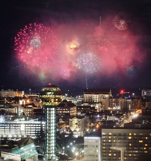 Fireworks exploding over Knoxville city skyline at night with Sunsphere tower visible