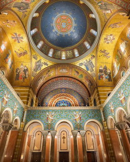 Ornate basilica interior with golden dome, colorful mosaics, and arched architecture