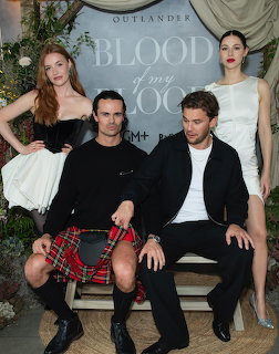Four actors posing in formal outfits around a bench with Blood of my Blood text behind them