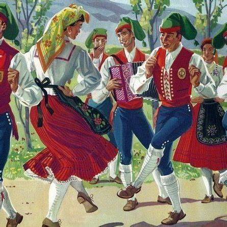 People in traditional folk costumes dancing outdoors with an accordion player