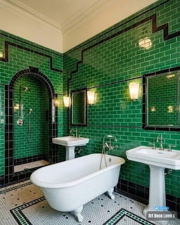 Art deco bathroom with green tile walls, white clawfoot tub, and black-white hexagonal floor