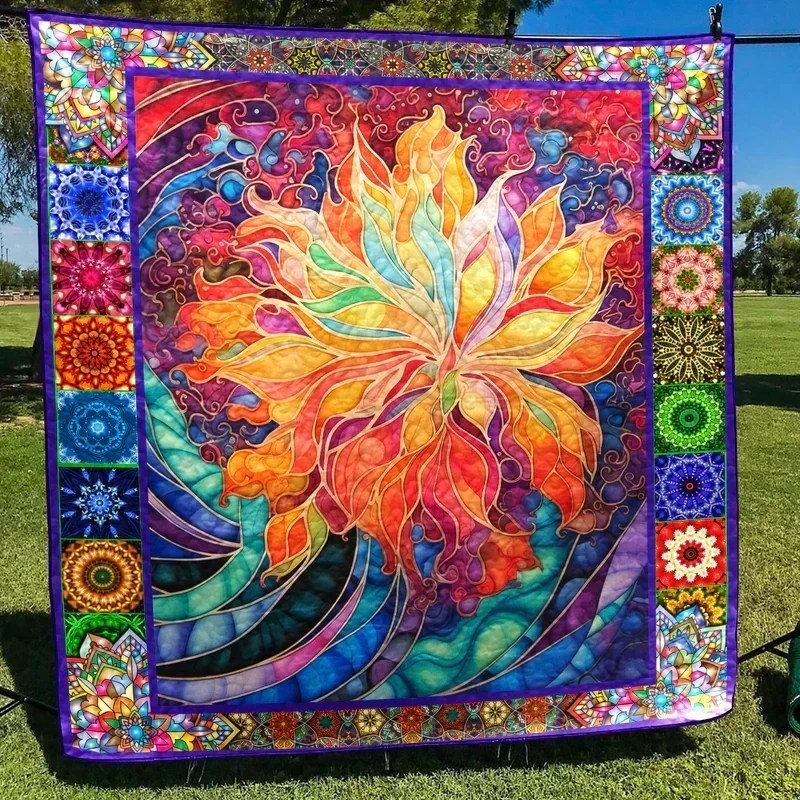 Colorful quilted fabric art with large central flower and patchwork border hanging outdoors