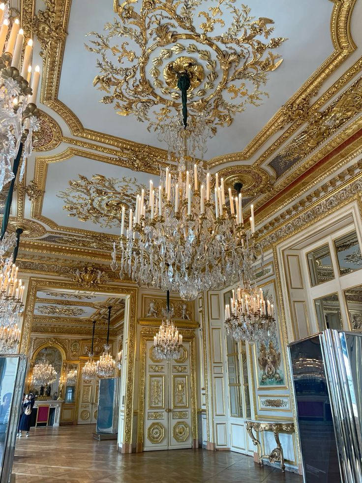 Grand gilded interior with crystal chandeliers, mirrors, and ornate ceiling details