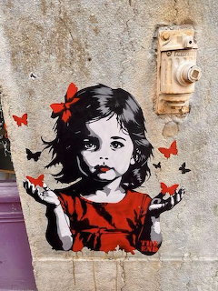 Street art stencil of girl with butterflies on concrete wall