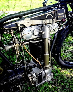 Close-up of a vintage Sgonina Special motorcycle engine with black cylinder and chrome pipes