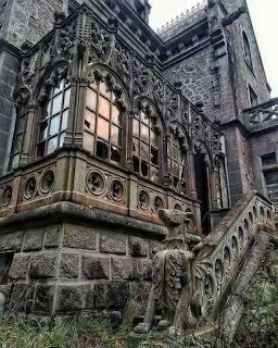Abandoned Gothic stone castle with intricate carved stone windows and a weathered staircase