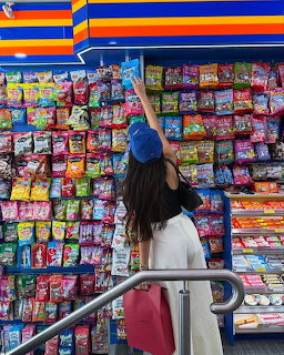 Woman reaching for colorful snacks on a store wall display