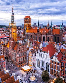 Aerial view of historic Gdansk Old Town with red-roofed buildings, Gothic cathedral, and ornate tower