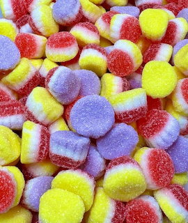Close-up pile of colorful sugar-coated gumdrops in yellow, red, and purple