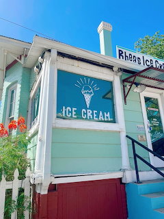 Turquoise ice cream shop exterior with white trim and a large ice cream sign